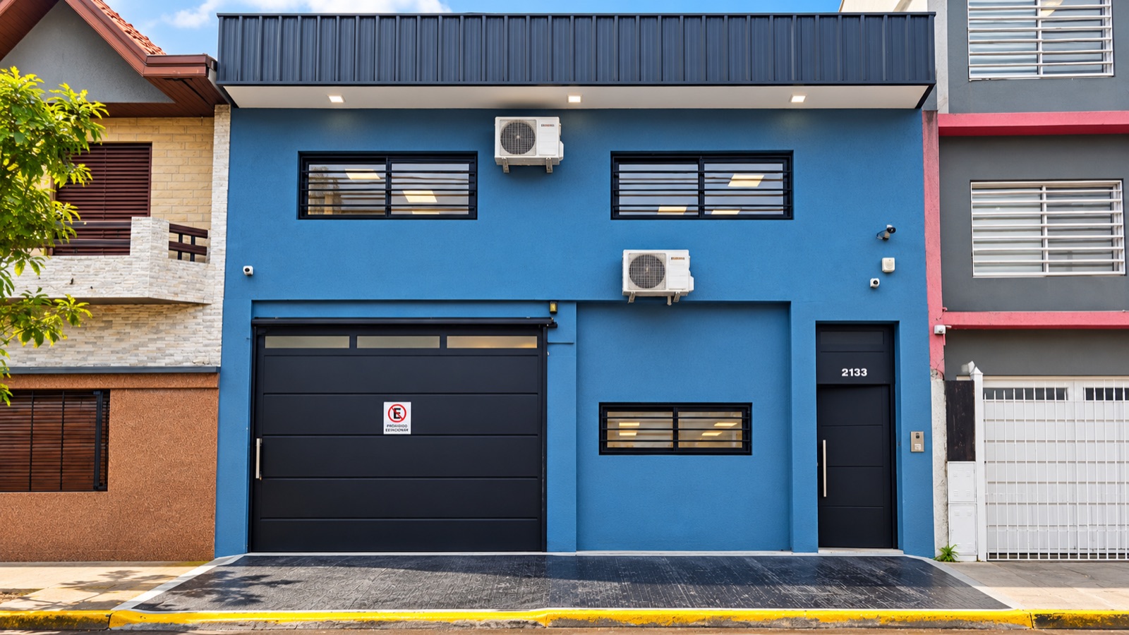 Frente del depósito de Distribuidora Pilcomayo, pintado de azul con portón negro